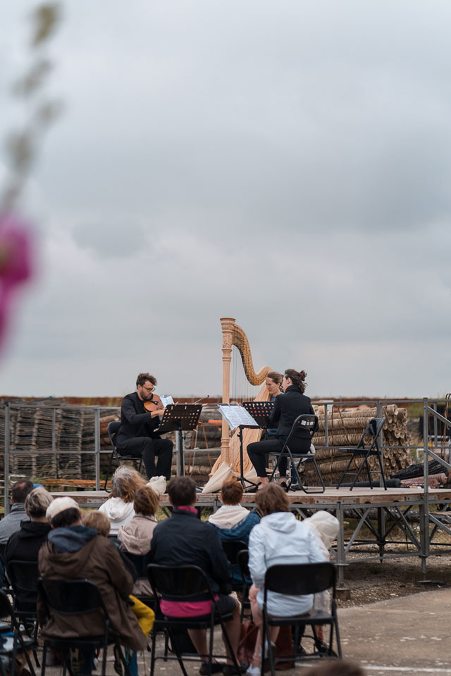 Concert d'un trio, la harpiste, le violoniste et la flutiste lors d'un concert dans les claires de l'éco-musée de Port Des Barques