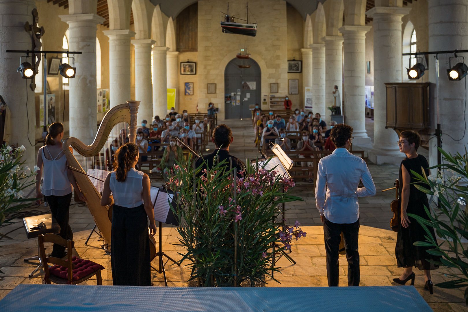 musiciens de dos avec leur instrument à cordes dans une église